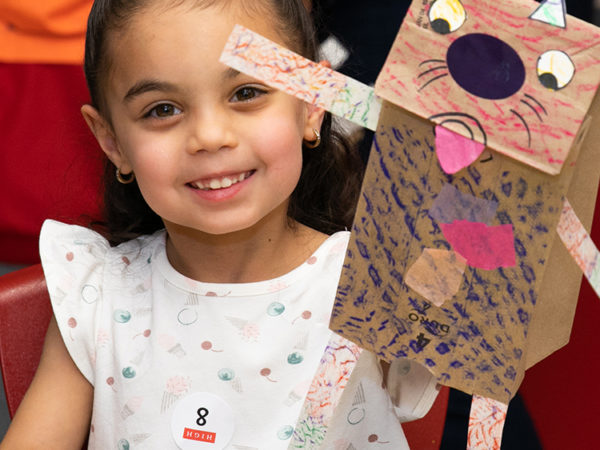 Child holding paper bag puppet