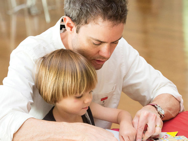 Parent helping child with art activity