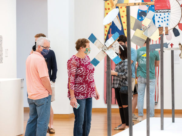 Visitors look at artwork in galleries