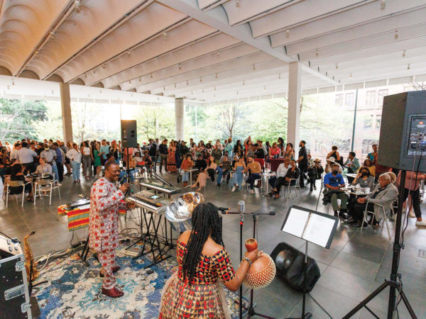 A small band performs for a crowd on the Orkin Terrace of the museum.